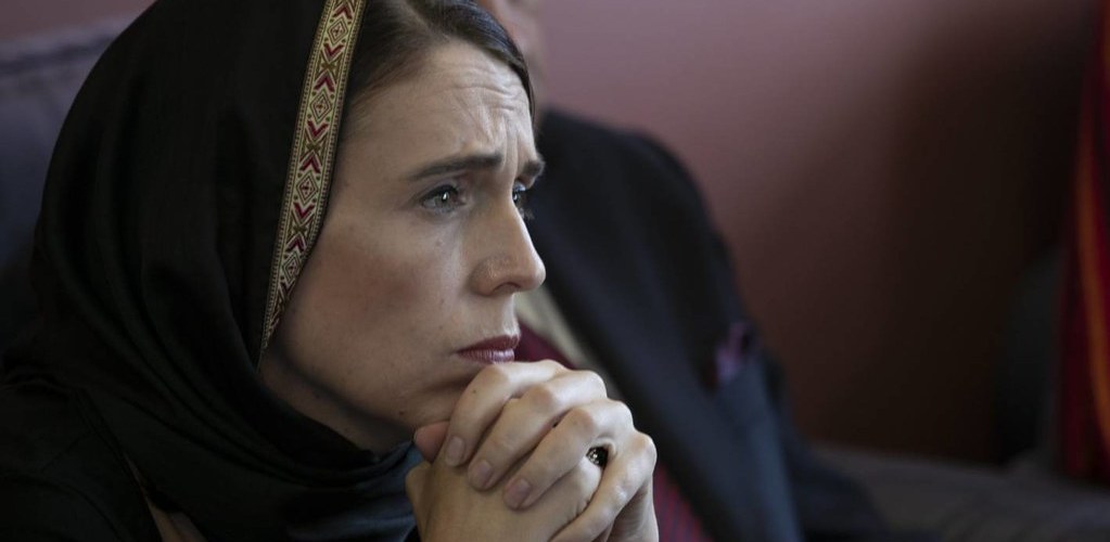 Jacinda Ardern, in profile, with her hands clasped underneath her chin.